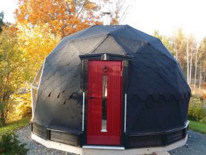 Kupolformad bastu med fin röd dörr